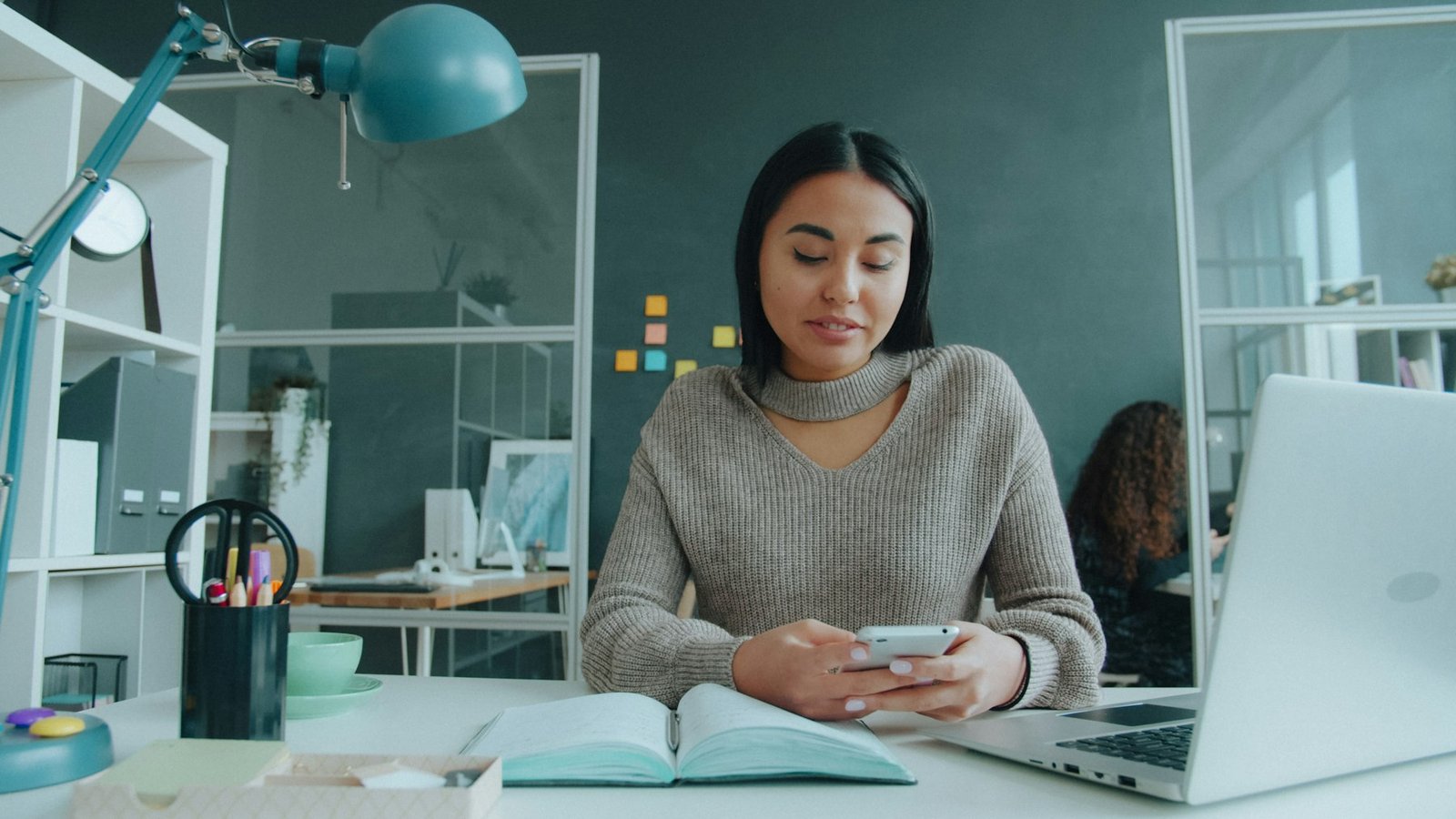 Business owner reading on her phone at her desk