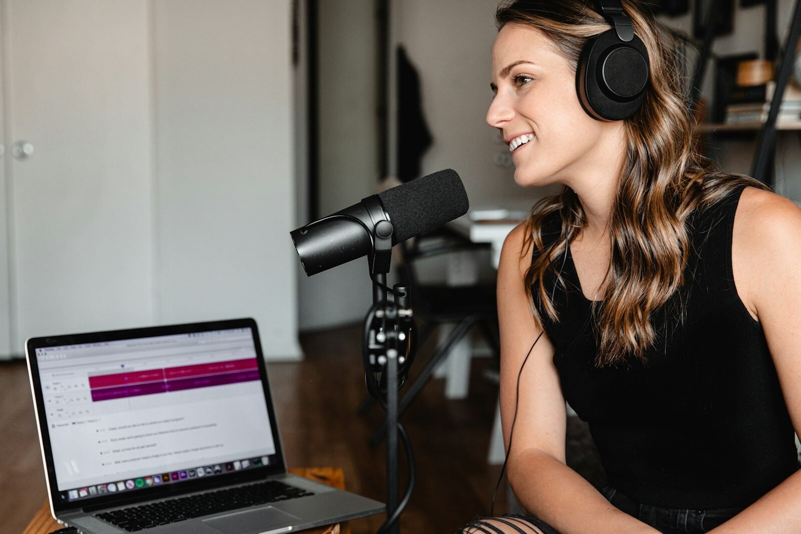 Business owner recording a podcast episode with a microphone and laptop