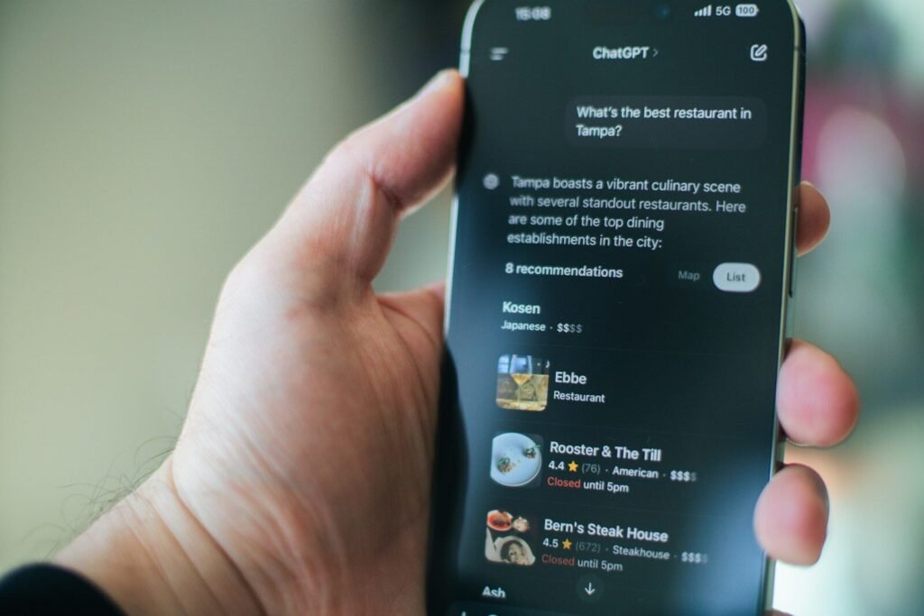 Hand holding a phone showing ChatGPT recommending local businesses