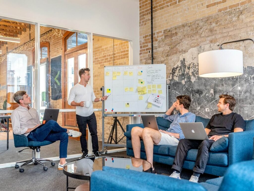 Marketing team planning around a whiteboard with laptops
