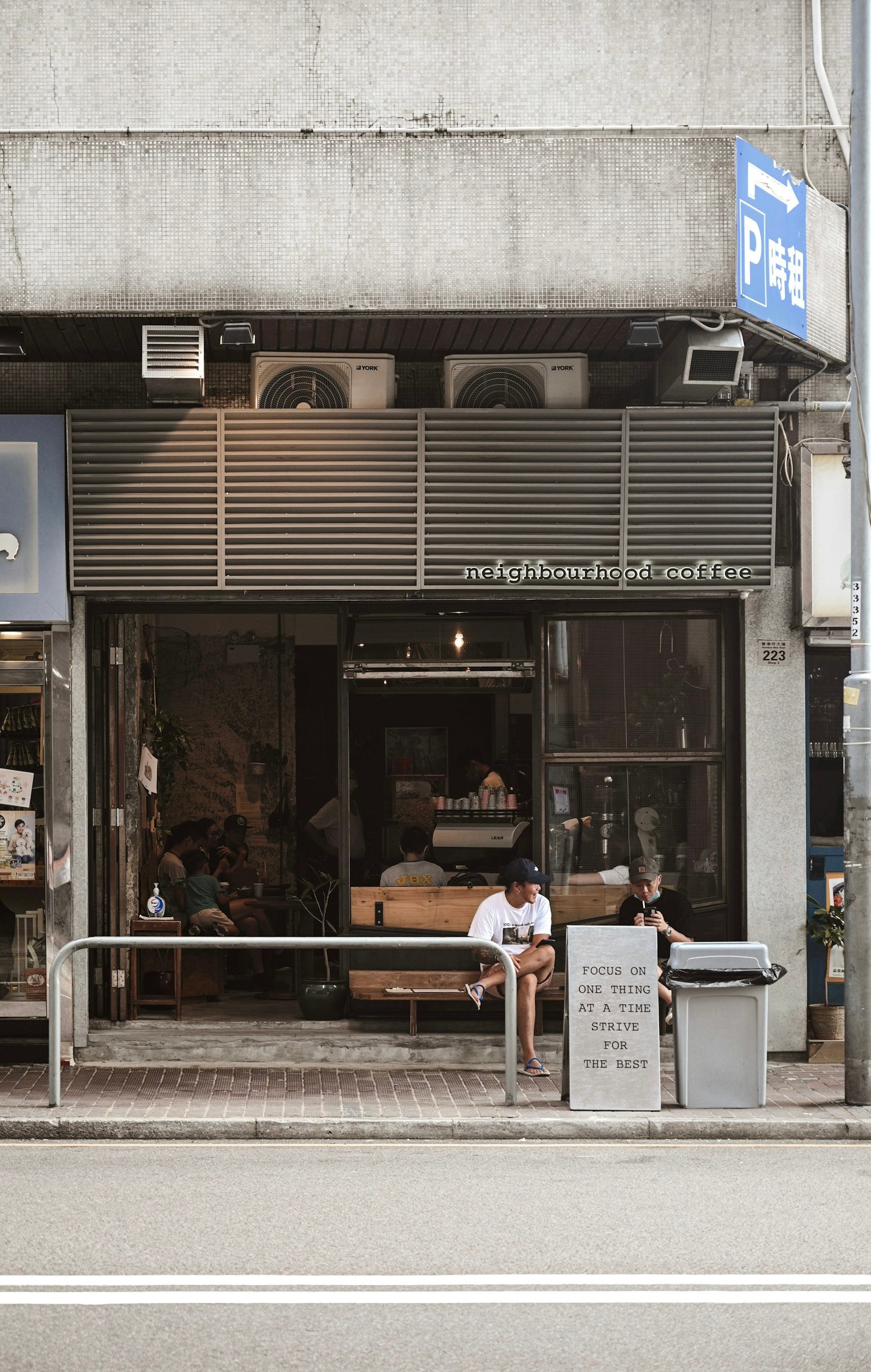 Street view of a shopfront with customers sitting outside