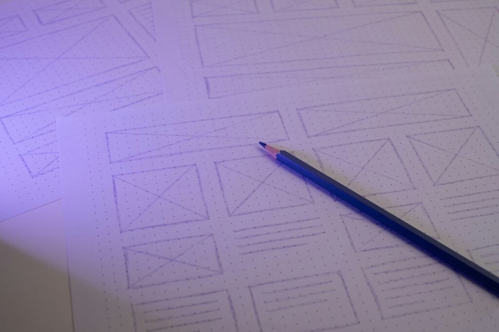 Pencil on grid paper with hand-drawn website wireframe sketches